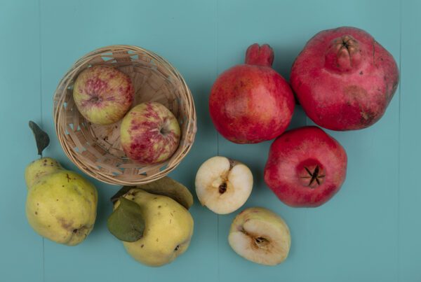 Imagen de Vista superior de manzanas frescas en un cubo con granadas y membrillo